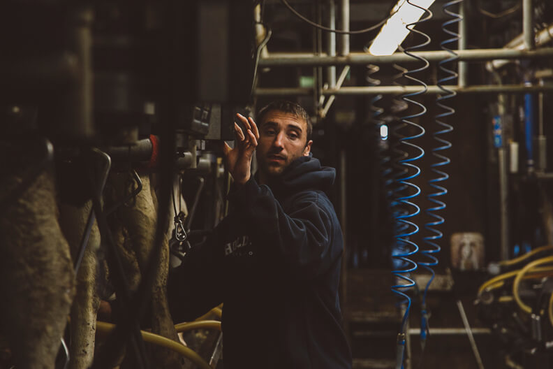 Worker in dark jacket operates machinery amid industrial mechanical equipment