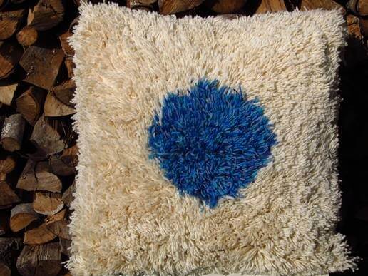 Fluffy cream-colored cushion with a vibrant blue heart-shaped center