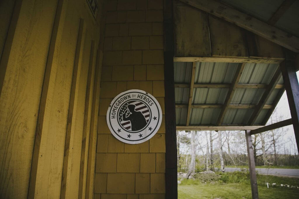 Homegrown by Heroes logo on wooden wall with outdoor view
