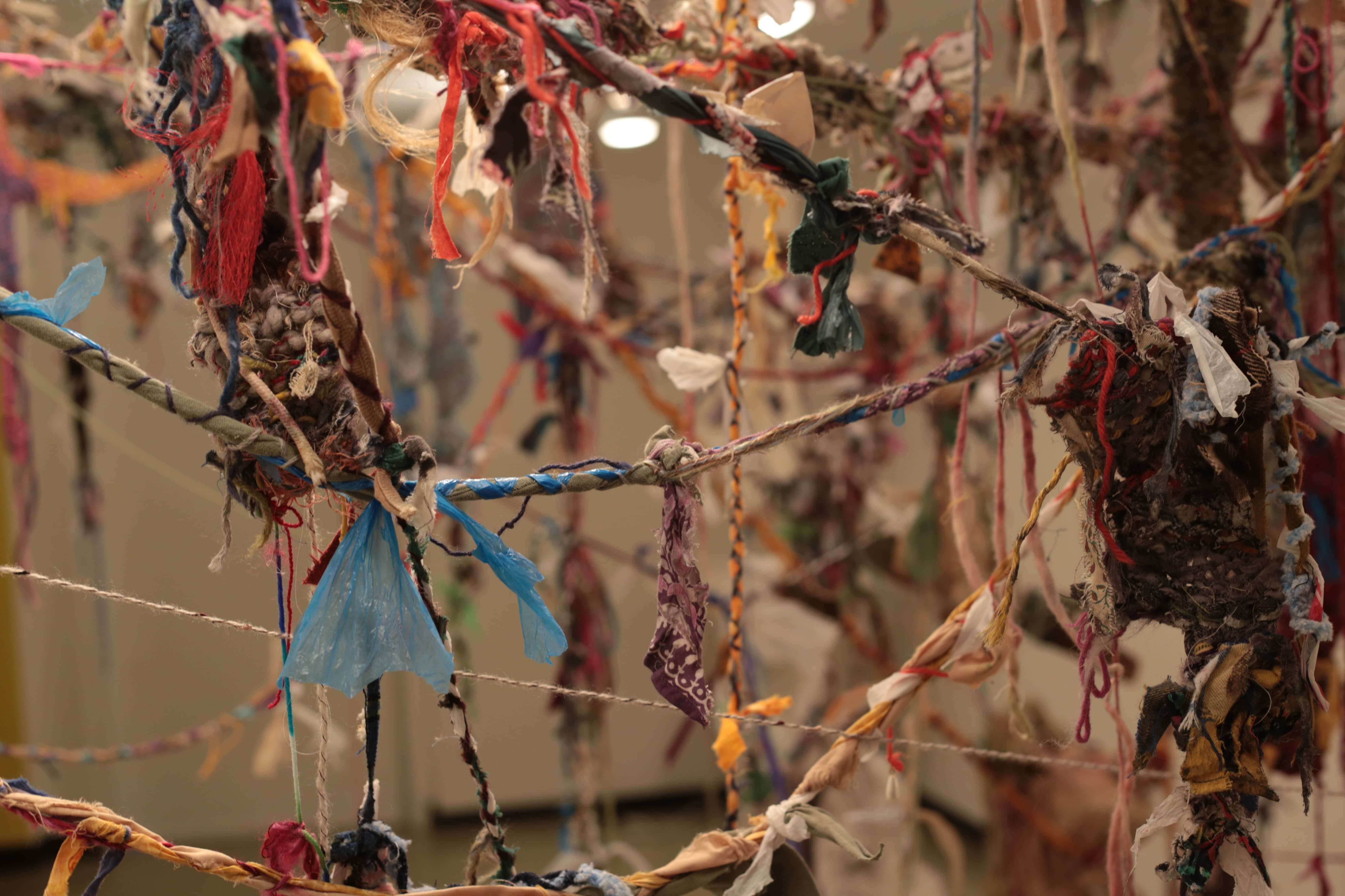 Tangled colorful fabric and yarn strings hanging on interconnected branches