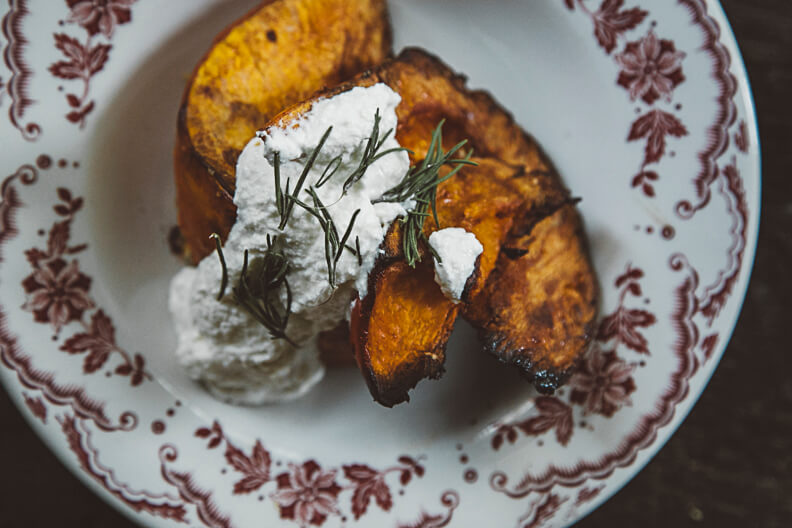 Roasted golden sweet potato with white cream and fresh dill garnish