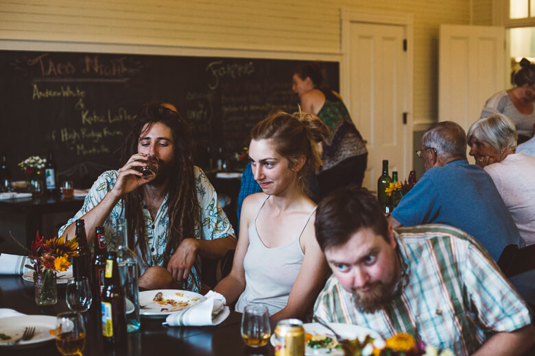 Friends enjoying casual meal together at rustic restaurant with chalkboard menu