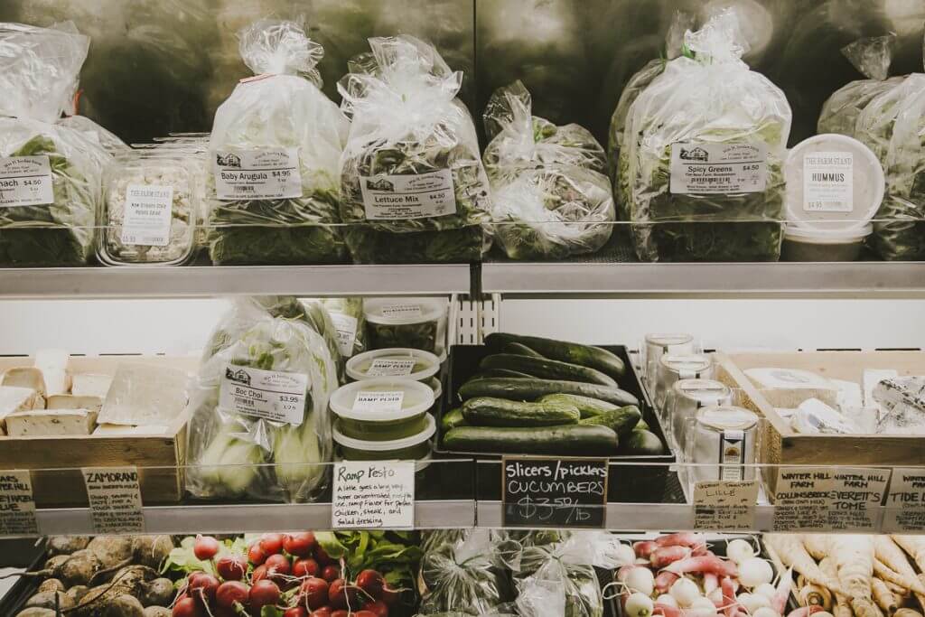 Fresh produce and packaged salads displayed on shelves in a grocery store