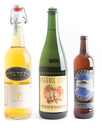 Three artisan bottles of craft cider with unique labels and colors