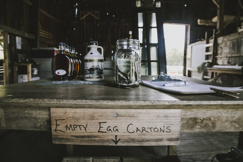 Rustic workspace with jars, bottles, and "Empty Egg Cartons" sign