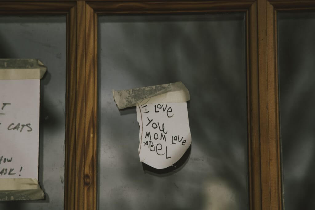 Handwritten note saying "I love you mom love Abel" on blurry background