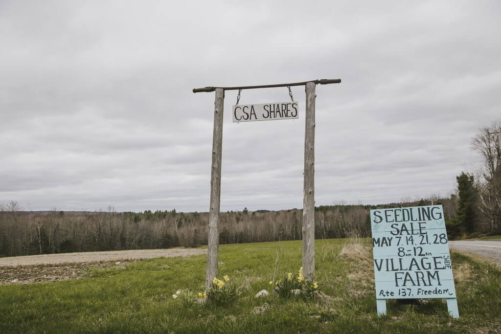 CSA shares sign and seedling sale notice at rural Village Farm