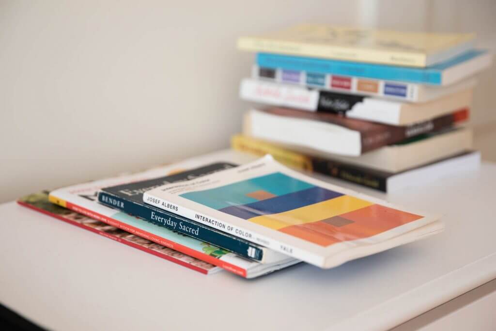 Colorful stack of art and design books on a white surface