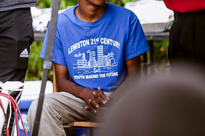Person wearing blue Lewiston 21st Century youth program t-shirt