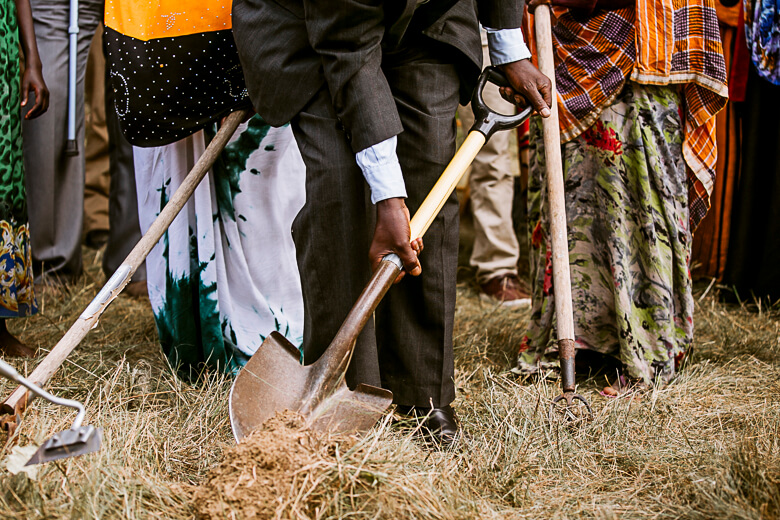 Community members with shovels participate in ground breaking ceremony
