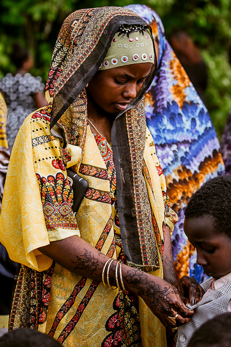Woman in ornate yellow and black traditional dress with henna tattoos