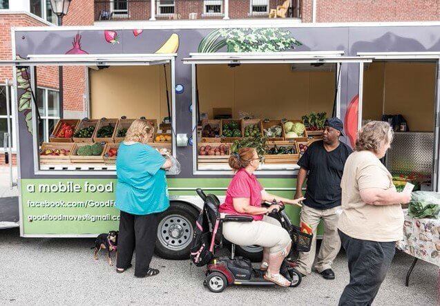 People shopping at mobile farmers market with fresh produce