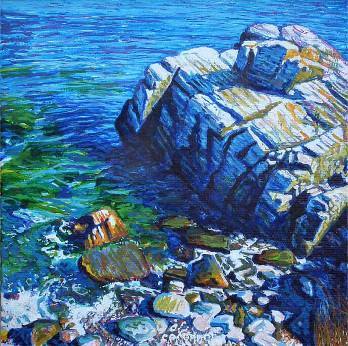 Rocky coastline with blue water and vibrant painted rocky seashore