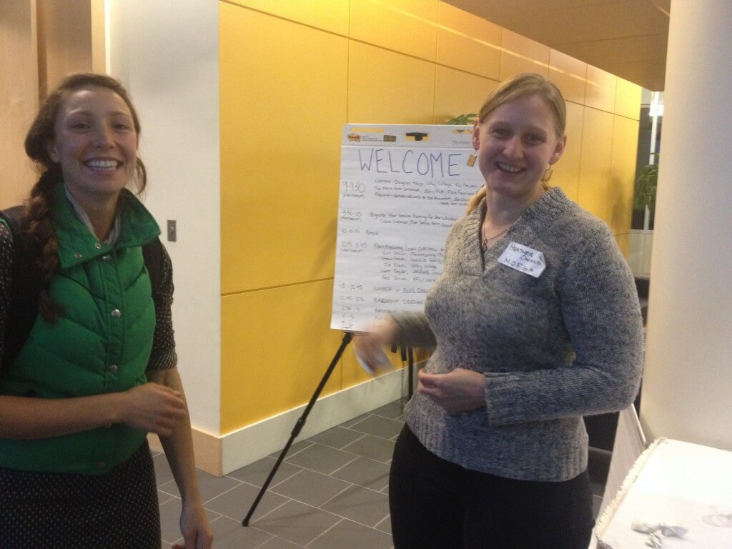 Two smiling people with a welcome sign in a bright yellow room