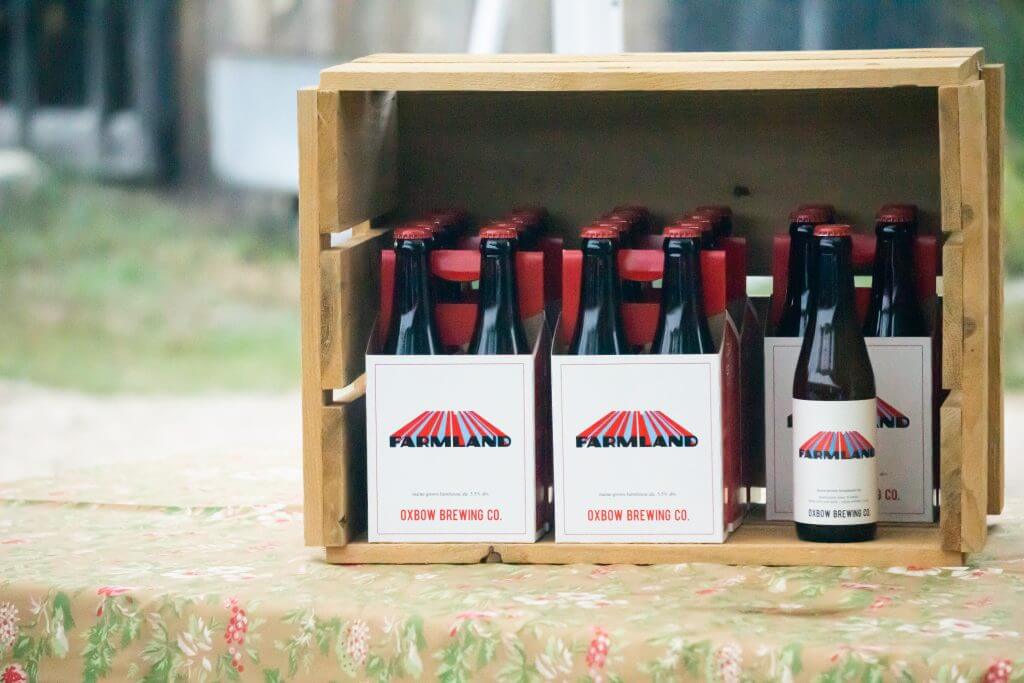 Farmland beer bottles from Oxbow Brewing Co. in wooden crate