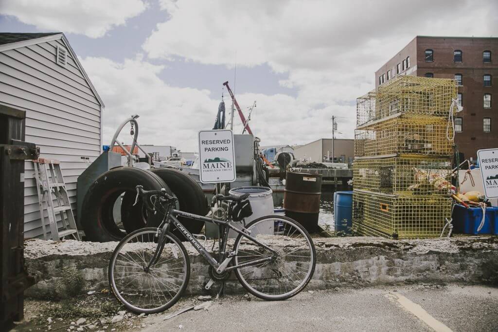 Bicycle parked near Maine lobster traps and industrial building