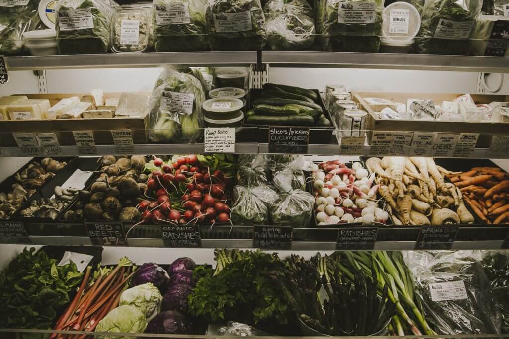 Fresh produce display with variety of organic vegetables and labeled shelves
