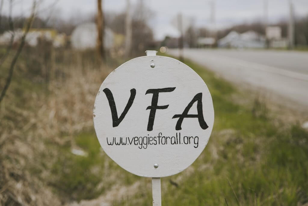 White VFA sign with www.veggiesforall.org on roadside