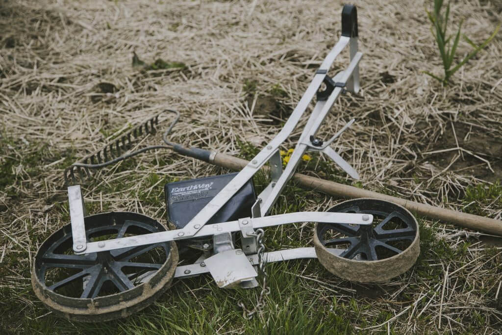 Agricultural measuring wheel on grassy ground with wooden handle