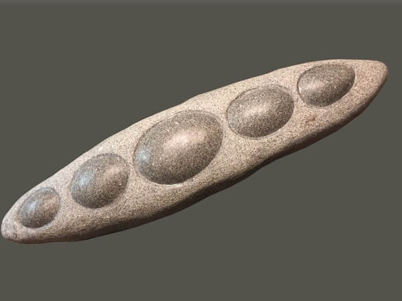 Ancient stone tool with smooth oval indentations, prehistoric artifact