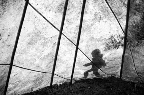 Silhouette of a person inside a tent with geometric wire frame