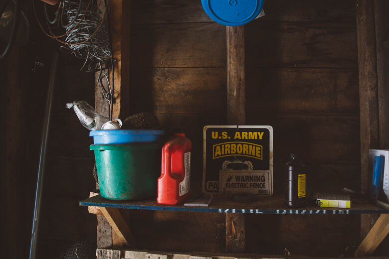 Old wooden shelf with US Army Airborne sign, green bucket, and red container