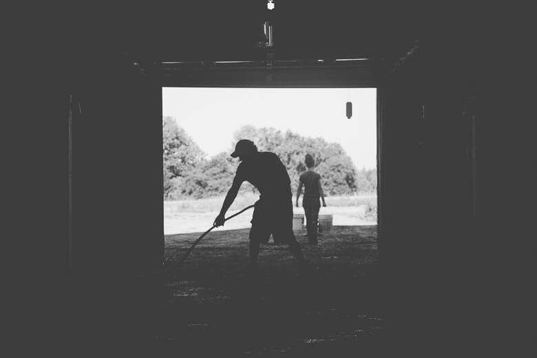 Silhouetted figures working with gardening tools in doorway