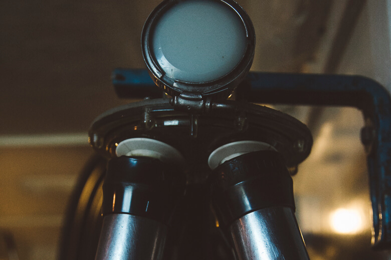 Vintage camera with round viewfinder and metallic body in low light