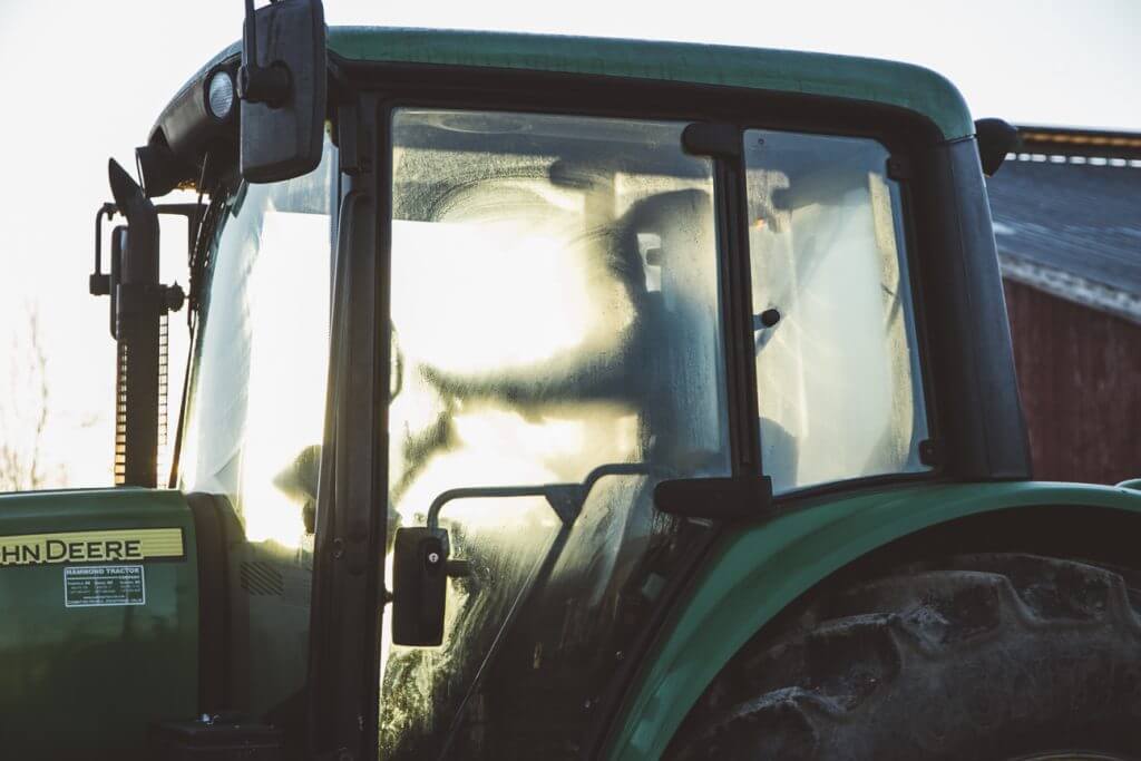John Deere tractor cab with sunlight streaming through frosted windows