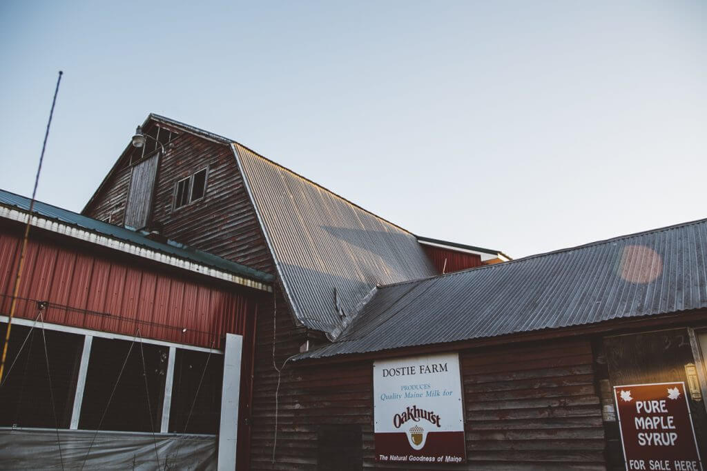 Rustic wooden farm buildings with Oakhurst milk and maple syrup signs