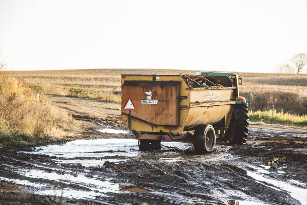 A dump truck driving down a muddy road