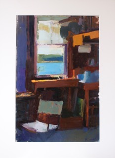 Artist's studio with window overlooking blue water and wooden workspace