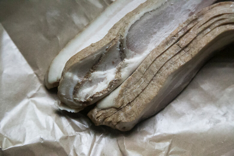 Ripe banana with brown spots on crumpled white paper