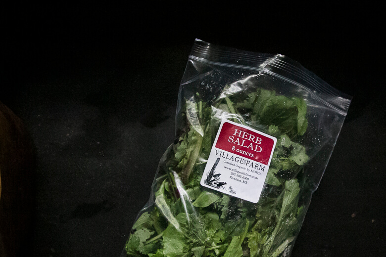 Packaged herb salad from Villagefarm in clear plastic bag