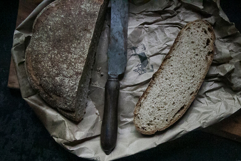 Rustic bread loaves and vintage knife on crumpled paper