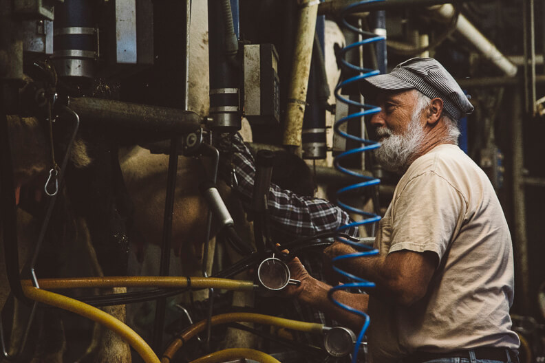 Experienced worker operating machinery in industrial workshop wearing cap