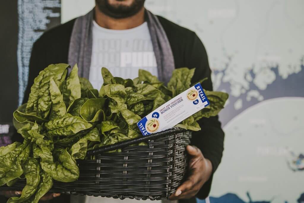 Fresh green spinach leaves in basket with voucher