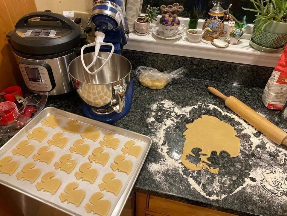Baking elephant-shaped cookies with mixer, rolling pin, and flour