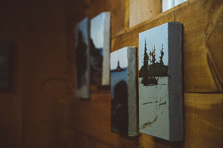 Wooden wall with blurred art prints featuring silhouette landscape scenes