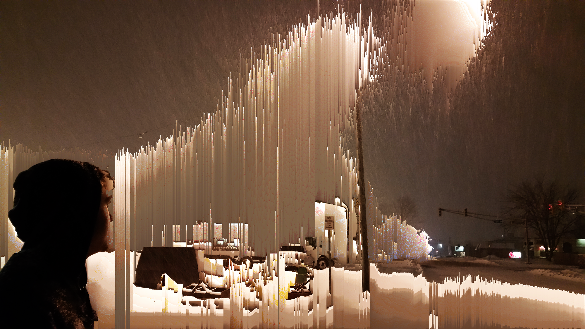 Glitch art of a hooded figure looking out over a snowy street at night, with pixels dripping in vertical streaks below a glowing streetlight