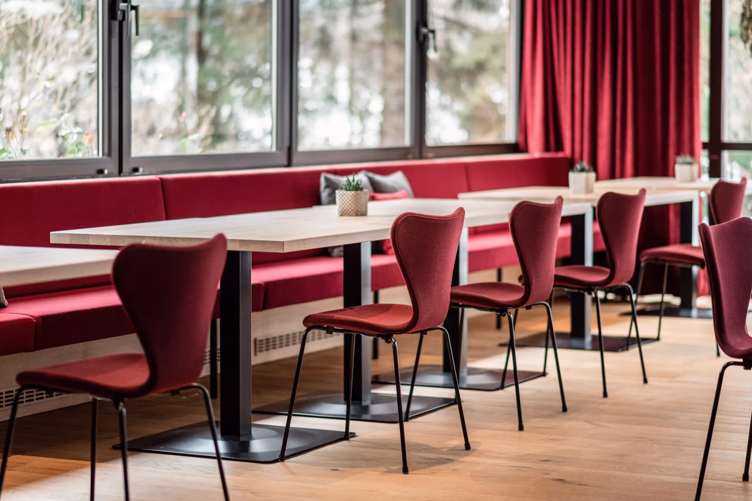 Detailaufnahme des Speisesaals vom Sporthotel Alpenland mit rotem Stoffbezug