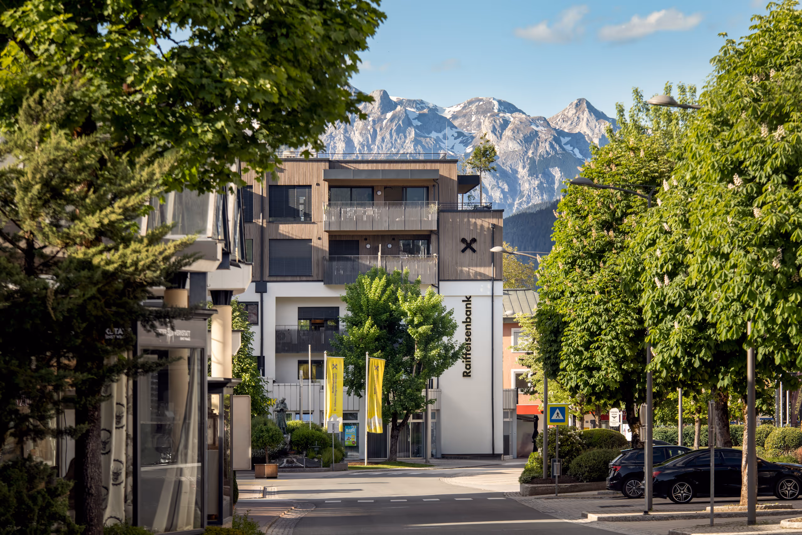 Architekturfoto des Raiffeisengebäudes in St. Johann im Pongau mit Tennengebirge im Hintergrund – Außenaufnahme nach Umbau
