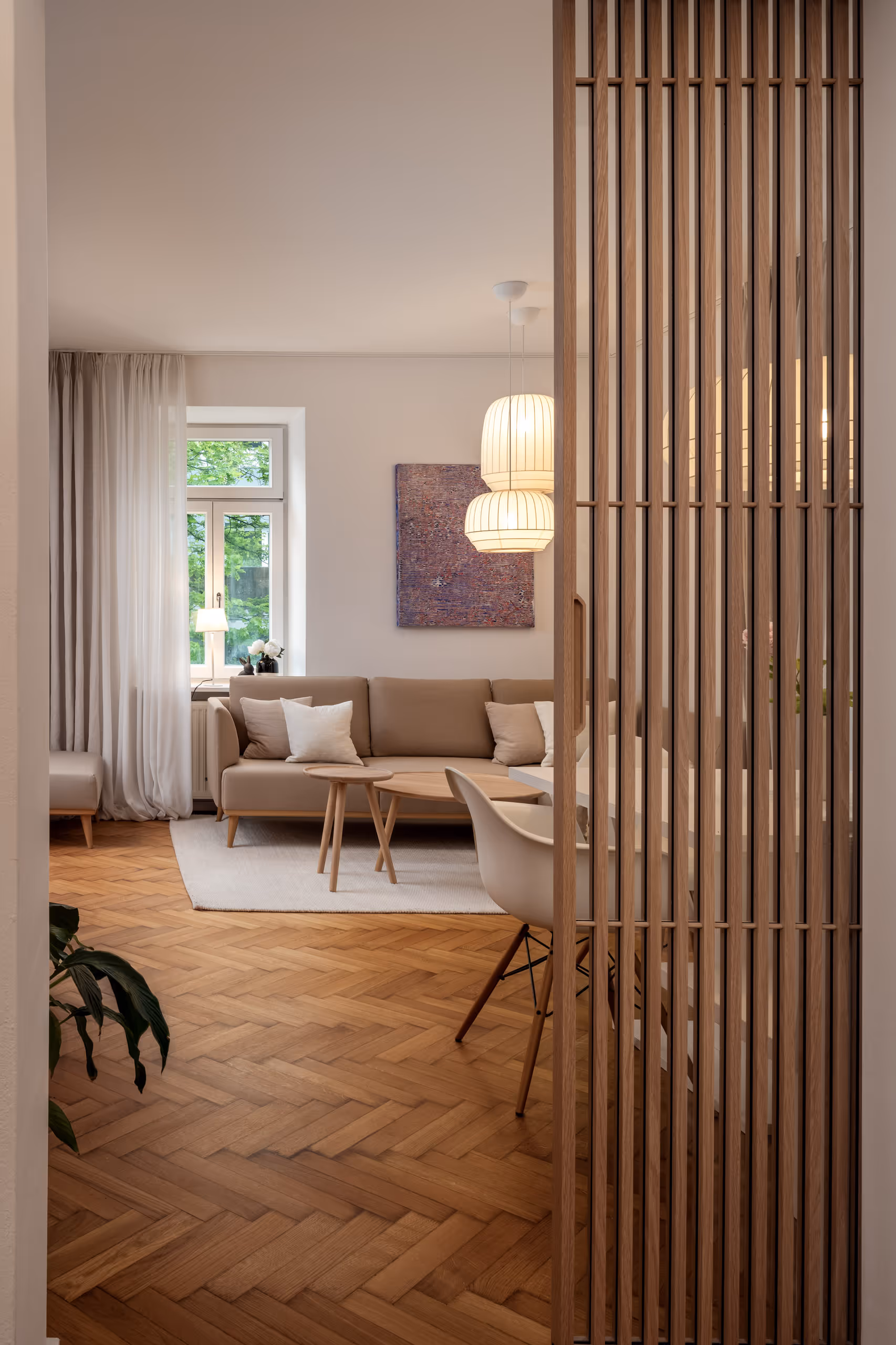 Interiorfoto eines gemütlich gestalteten Wohnzimmers mit Holzlamellenwand – Referenzprojekt für M-Studio Reiter in Salzburg