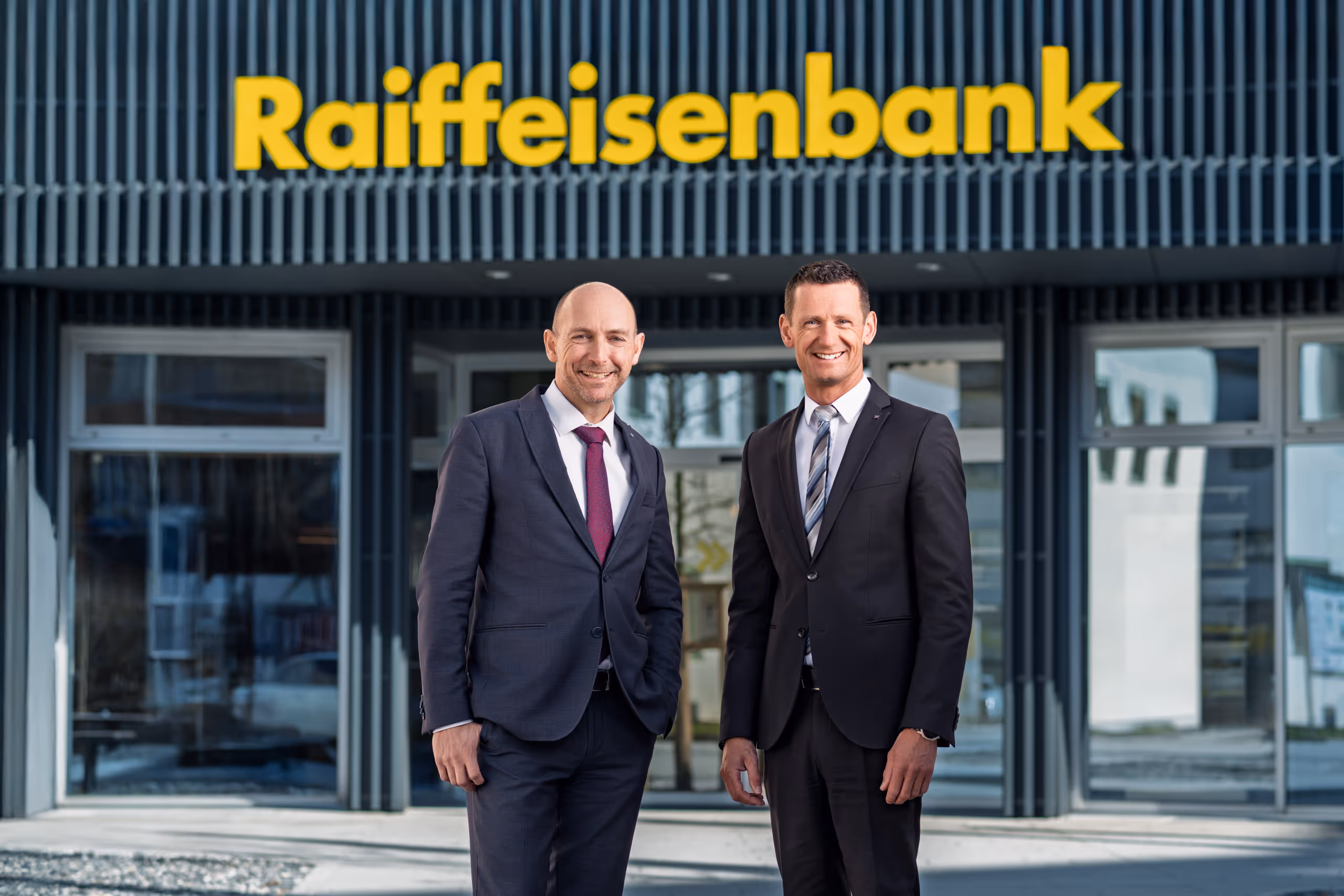 Portrait der Raiffeisenbank-Geschäftsführer Klaus Santner & Christopher Preßlaber vor der Filiale in St. Johann im Pongau