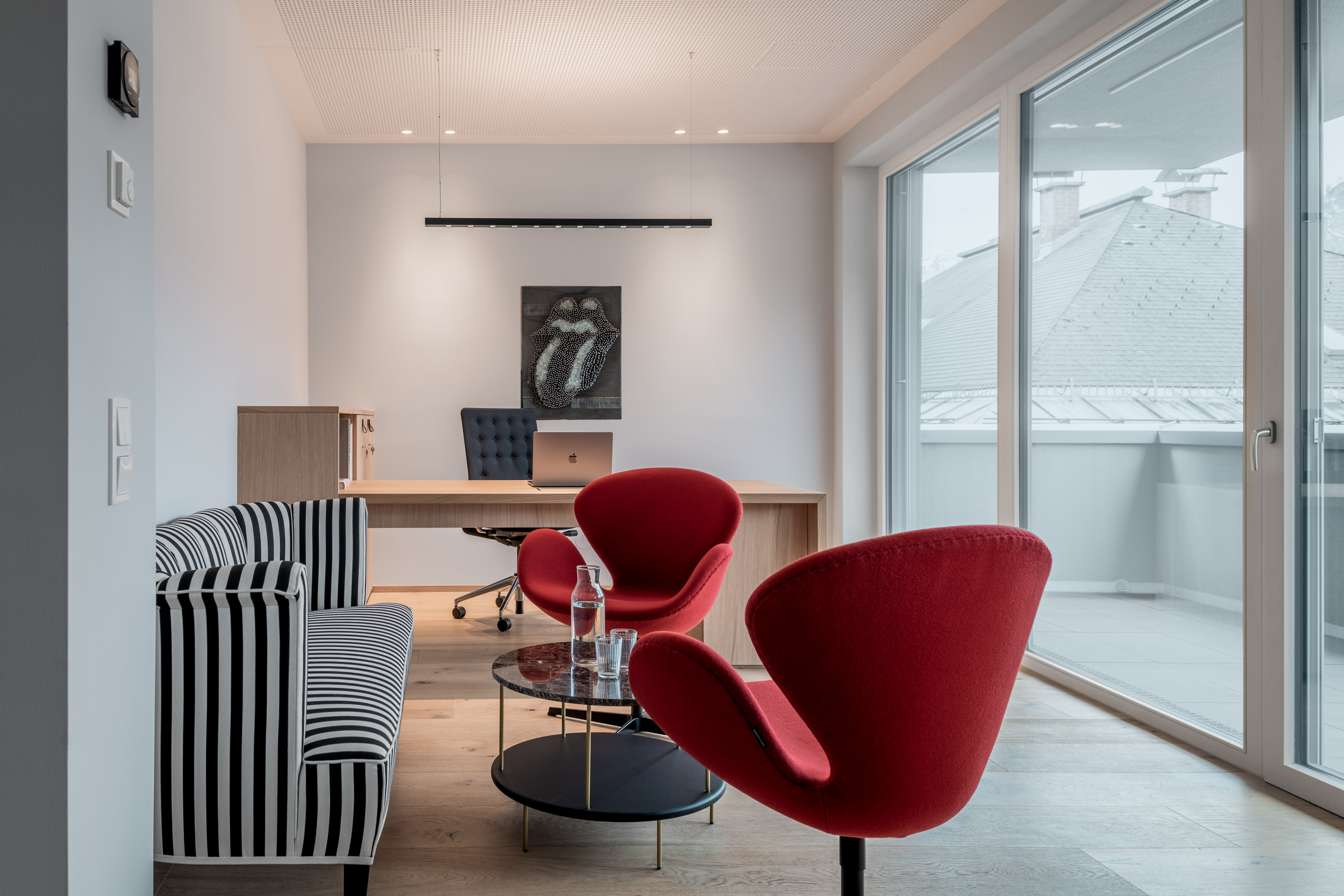 Modernes Büro im Zentrum von St. Johann im Pongau mit farbigen Details und Holzelementen, gestaltet von Frame Innenarchitektur.