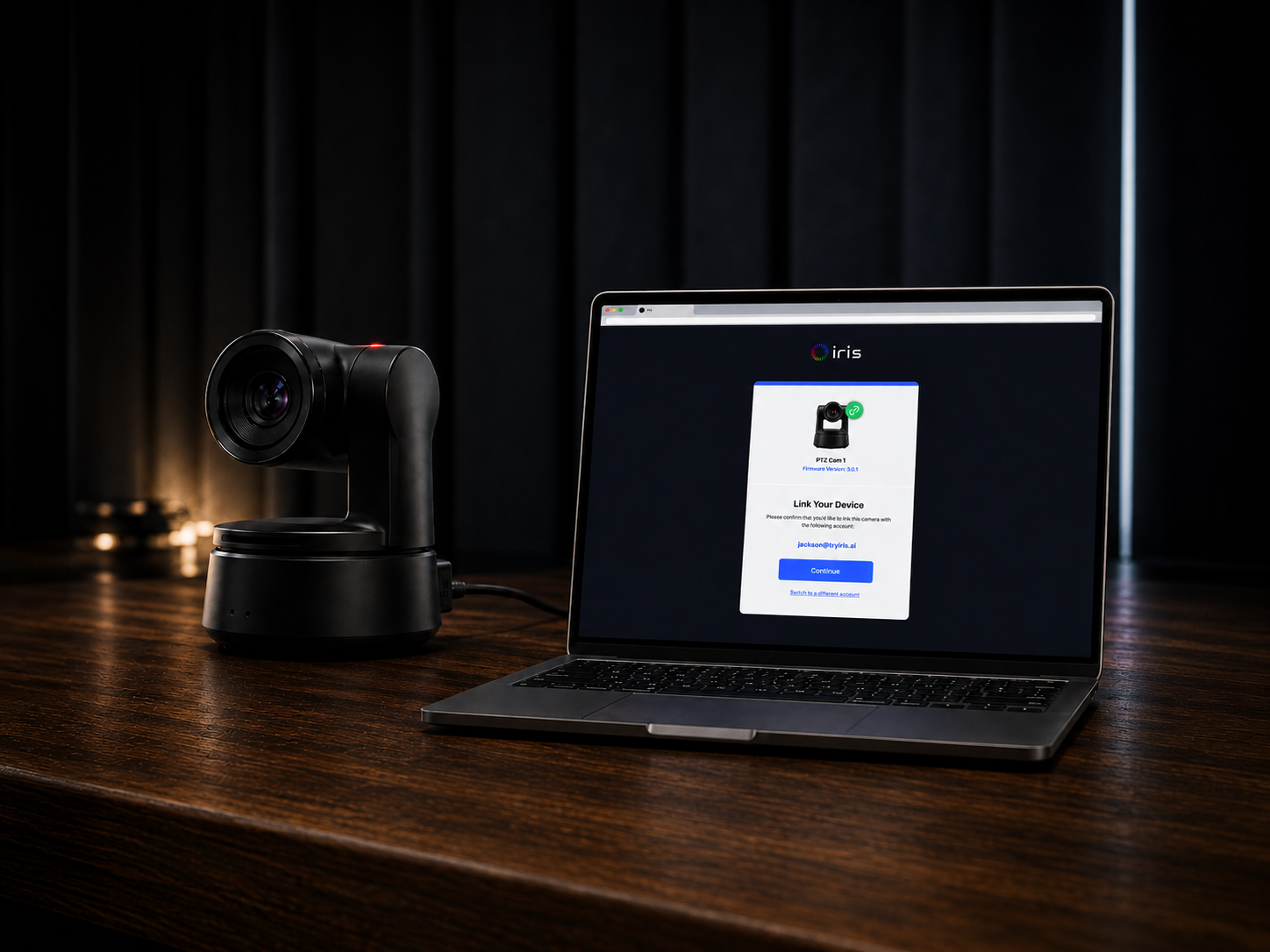 The camera on a desk beside a laptop showing the Iris link confirmation
