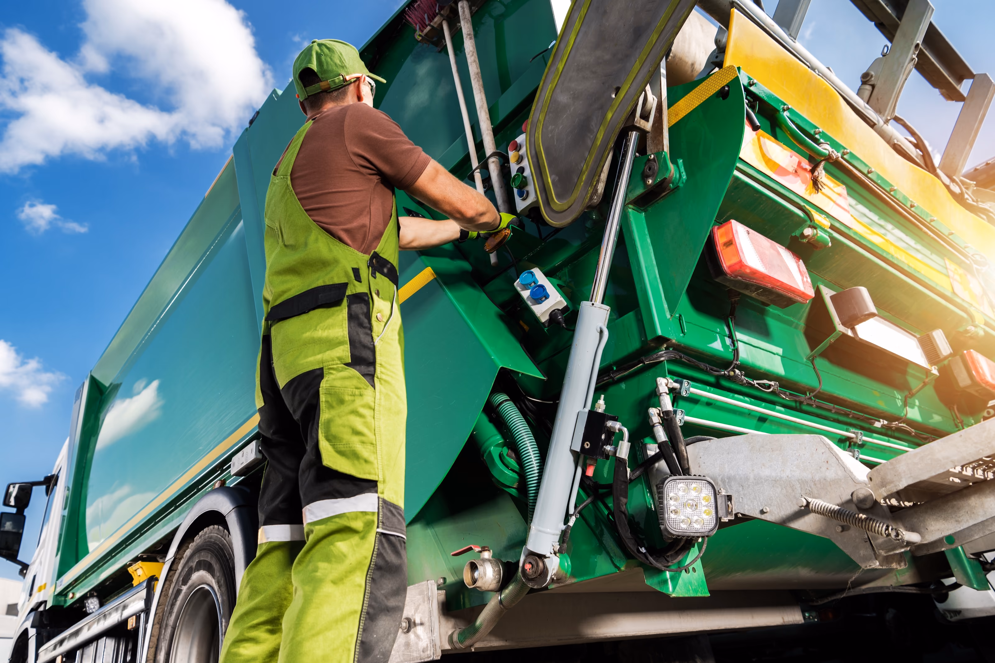 Waste collection worker operating a garbage truck