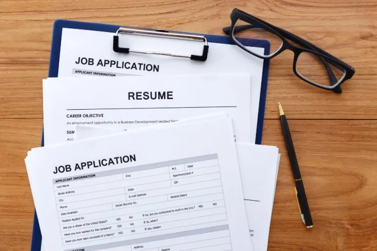 Photo of a resume, a pen and glasses