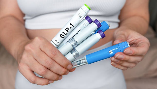 Woman holding multiple GLP-1 injection pens comparing peptide for weight loss options.