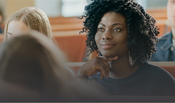 A young African-American woman listens intently during a workshop.